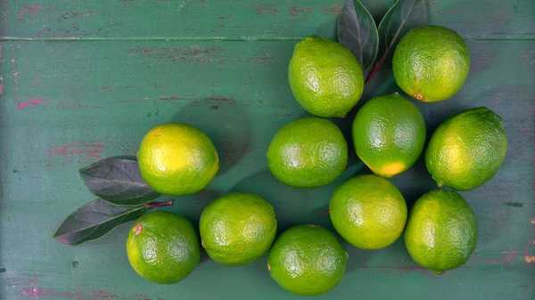 Limes sur table rustique en bois vert foncé — Photo