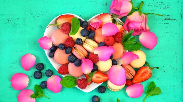 Petit Fours prezentace macarons s ovocem a plátky růží — Stock fotografie