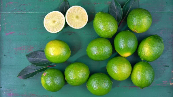 Limes sur table rustique en bois vert foncé — Photo