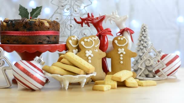 Mesa de comida navideña festiva con hombres de jengibre y pastel . — Vídeo de stock