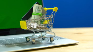 Minyatür alışveriş sepeti ve modern dizüstü E-ticaret alışveriş kavramı.
