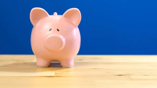 Piggy bank against blue background with copy space. — Stock Photo, Image