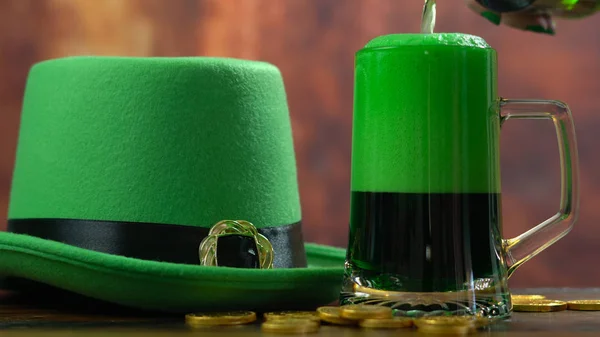 St Patricks Day derramando cerveja verde com chapéu de duende verde — Fotografia de Stock