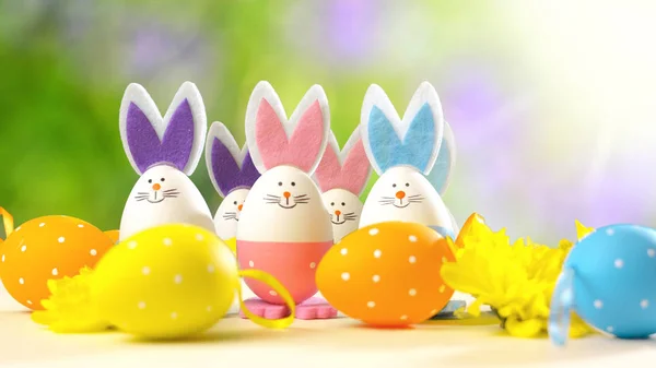 Easter bunny ornaments and Easter Eggs on white table against garden background — Stock Photo, Image