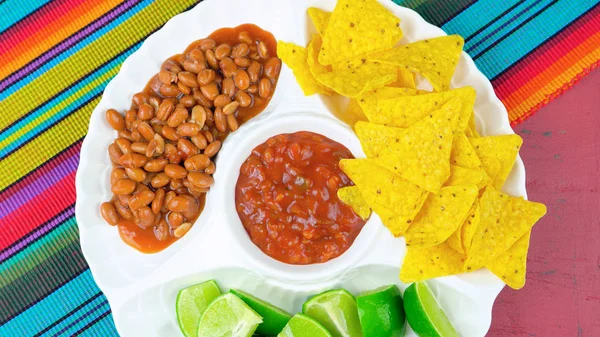 Cinco de Mayo partij voedsel schotel met maïs chips, Chili bonen en salsa. — Stockfoto