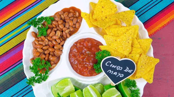 Plat de fête Cinco de Mayo avec chips de maïs, fèves de piment et salsa . — Photo