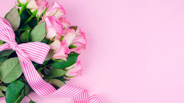 Mödrar dag bakgrund av rosa rosor med kopia utrymme på rosa trä bord. — Stockfoto