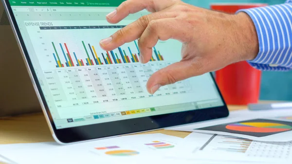 Empresario apuntando y expandiendo gráficos en la computadora portátil moderna de pantalla táctil . — Foto de Stock