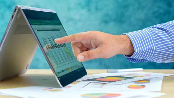 Geschäftsmann zeigt und erweitert Grafiken auf modernem Touchscreen-Laptop. — Stockfoto