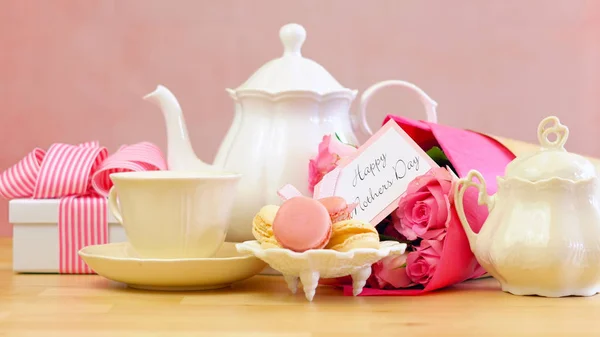 Día de las Madres ajuste de té con tetera, galletas macaron, rosas rosadas y regalo . —  Fotos de Stock