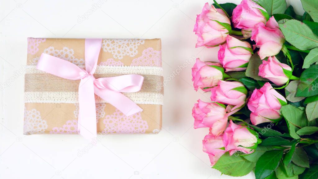 Mothers Day overhead with gift and pink roses on white wood table background