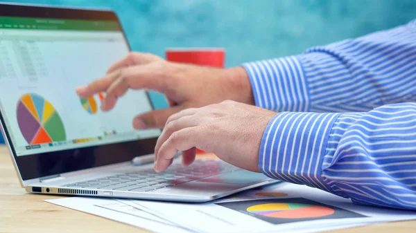 Empresario apuntando y expandiendo gráficos en la computadora portátil moderna de pantalla táctil . — Foto de Stock