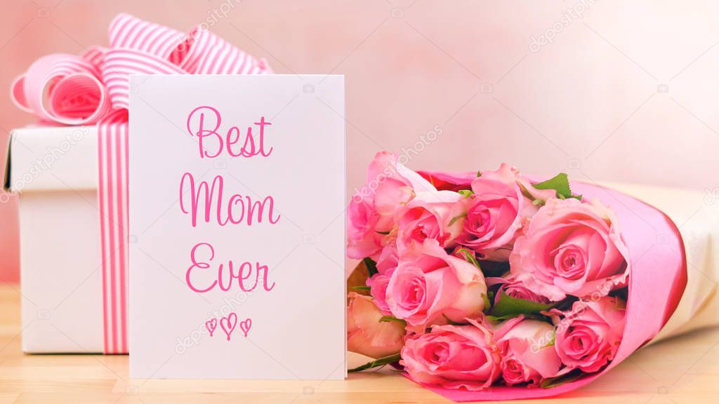 Mothers Day gift, pink roses and Best Mom Ever greeting card on table.