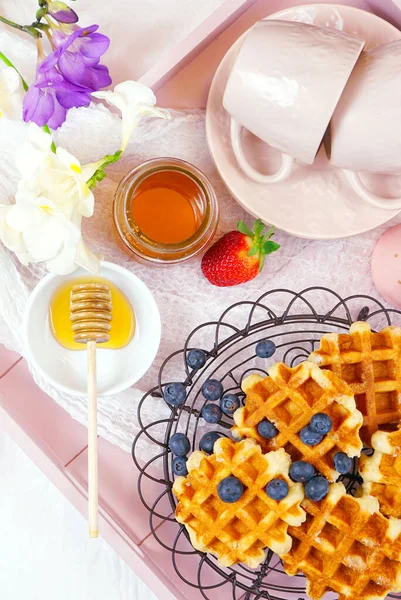 Moderno vassoio da colazione rosa arrossire con cialde, miele e frutta flatlay . — Foto Stock