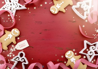 Noel zencefilli ekmeği ve süsleri kırmızı ahşap masa üzerinde sınır arkaplanı.