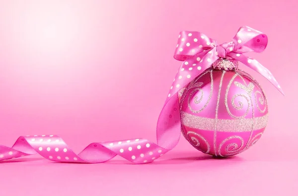 Festive pink Christmas holiday bauble on pink background. — Stock Photo, Image
