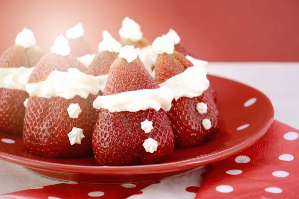 Kerst trakteert party food Aardbei Kerstmannen op rood en wit thema tafel. — Stockfoto