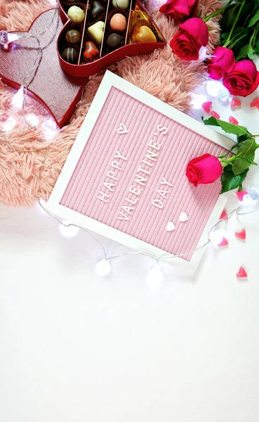 Día de San Valentín plano yacía con rosas, chocolates y cartón . — Foto de Stock