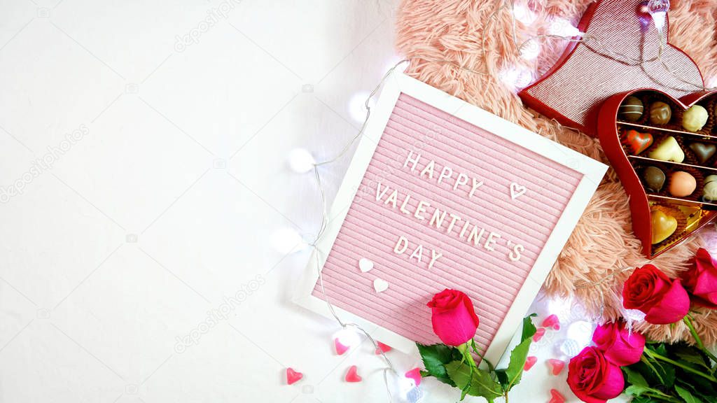 Valentines Day flat lay with roses, chocolates and letterboard.