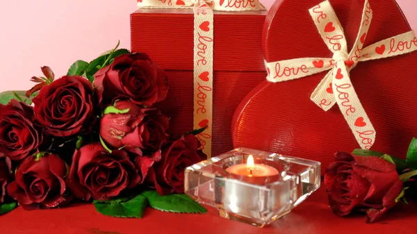 Valentijnsdag geschenken en rode rozen op rode houten tafel achtergrond. — Stockfoto
