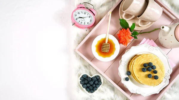 薄饼早餐盘，在床上放着糖浆和蓝莓果盘. — 图库照片