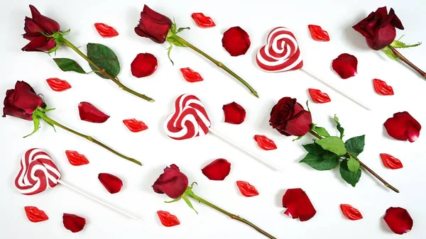 Red roses, petals, lollipops and chocolates creative composition layout. — Zdjęcie stockowe