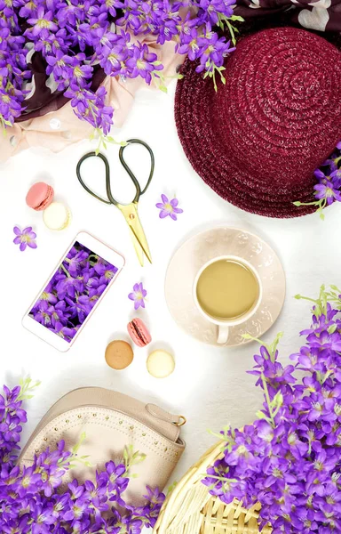 Весенняя раскладка с фиолетовыми цветами, кофе и женскими аксессуарами . — стоковое фото