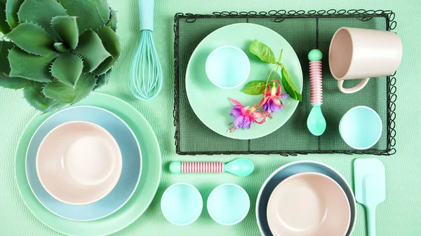 Modernes Pastellrosa, grünes und blaues Keramikgeschirr auf hellgrünem Untergrund. — Stockfoto
