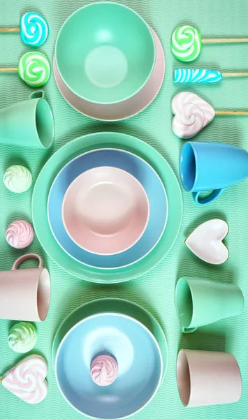 Modern pastel pink, green and blue ceramic tableware on pale green. — Stock Photo, Image
