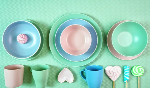 Nowoczesne pastelowe różowe, zielone i niebieskie ceramiczne zastawy stołowe na jasnozielonym. — Zdjęcie stockowe