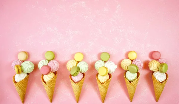 Summertime decorated border of ice cream cones with macarons and meringues. — Stock Photo, Image