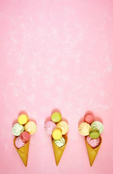 Summertime decorated border of ice cream cones with macarons and meringues. — Stock Photo, Image