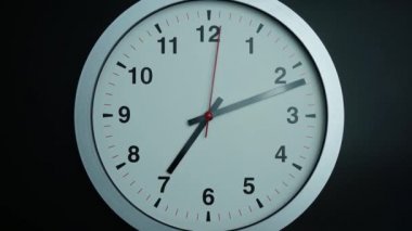 Yakınlaştır, yakınlaştır, gri duvar saati saat 7 'de siyah arkaplanda, zaman aşımına uğramış 60 dakika hızlı, zaman kavramı.