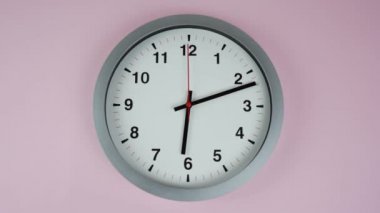 Gri duvar saati, saat 6: 00 'da pembe arka planda, zaman aşımına uğramış 60 dakika hızlı, zaman kavramı.
