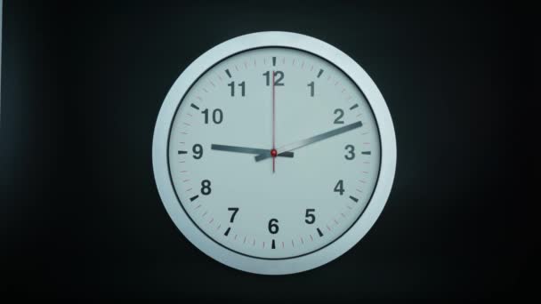 Horloge murale grise montre l'heure 9 heures sur fond noir, Time lapse 60 minutes se déplaçant rapidement, concept de temps .