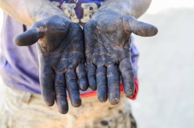 Yakından bak. Kirli elleri yağlı, tamirci.