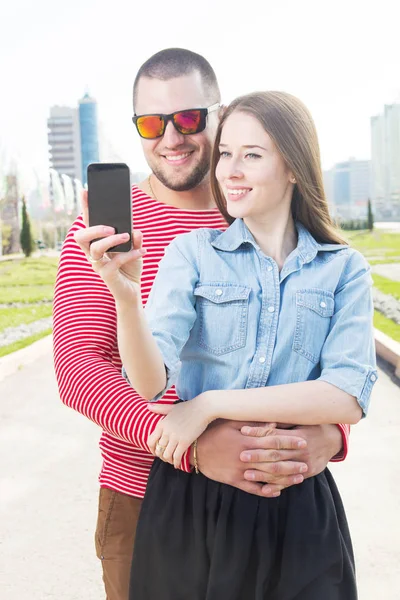 Homem e mulher bonita andando na rua e fazendo selfie por telefone inteligente . — Fotografia de Stock