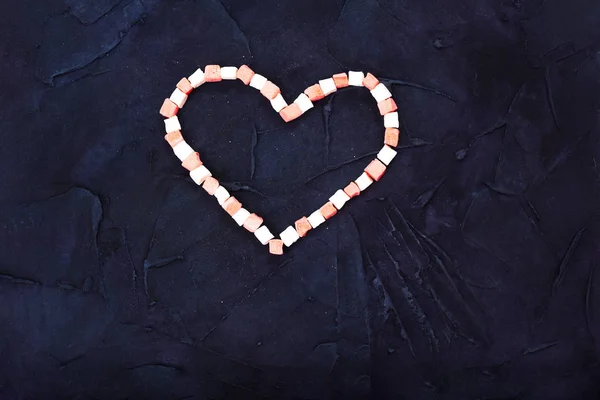 Symbole coeur de bonbons fond noir. vue de dessus . — Photo