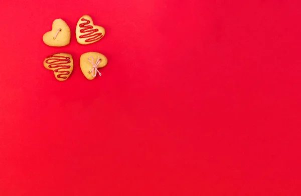 Biscuits colorés en forme de cœur sur plaque rouge — Photo