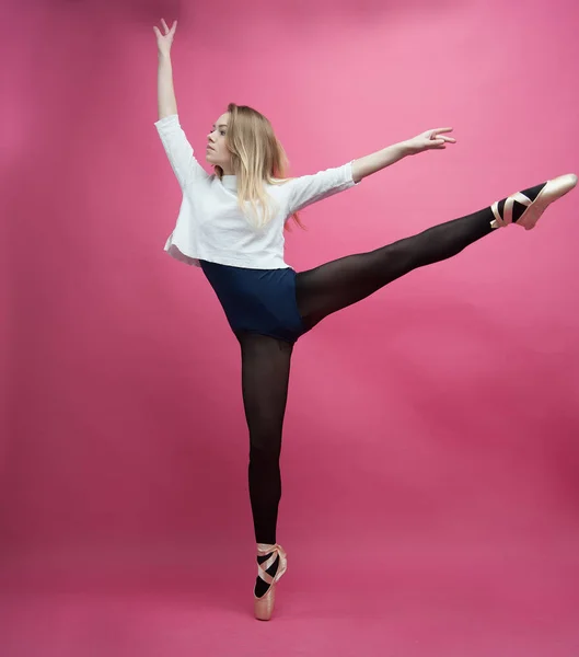 Menina em meias pretas dançando em um fundo rosa — Fotografia de Stock