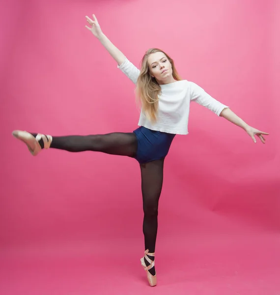 Chica en medias negras bailando sobre un fondo rosa — Foto de Stock