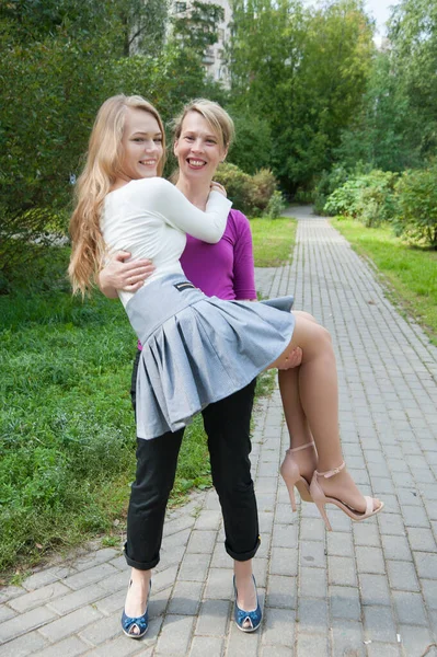 Due amiche ridono per strada — Foto Stock