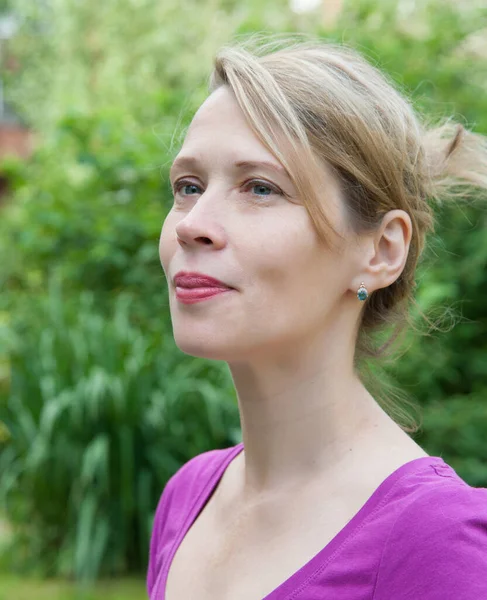 Portrait of a 40 years old woman in a summer park alone — Stock Photo, Image