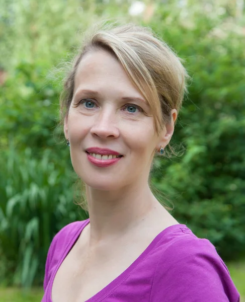 Portrait of a 40 years old woman in a summer park alone Stock Image