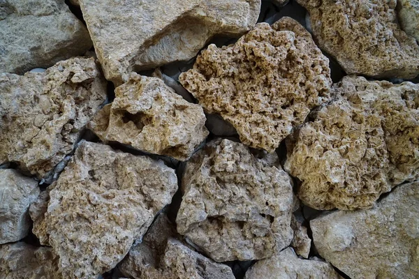 Büyük düzensiz taşları olan taş bir duvar.