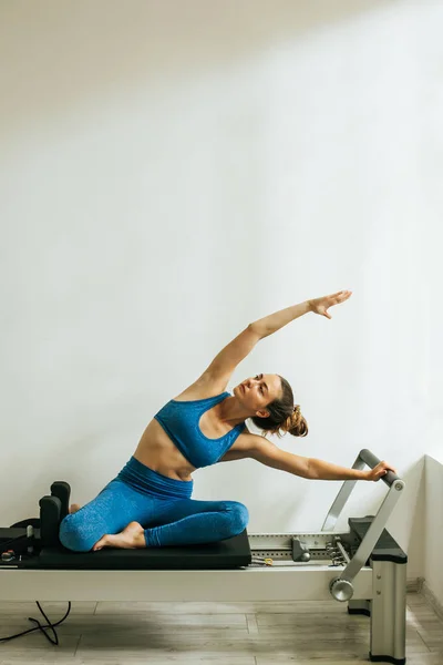 Bir Cadillac veya trapeze masa kullanarak Pilates Egzersiz yapan kadın