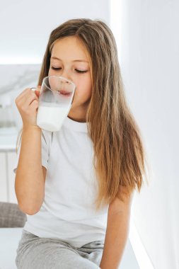küçük kız süt içerken gülümseyen 