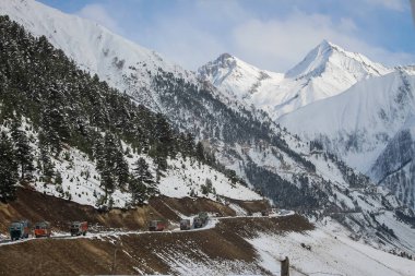 Drass'taki Himalayadağları'ndan geçen yolda yol üzerinde gezinen kamyon ve araçlar. Srinagar-Leh Otoyolu. Beacon. Kardeşim. Nhai