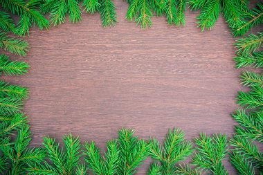 Ahşap bir masanın üzerinde ladin dalları