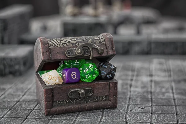 A treasure chest bulging with dice for role palying game.